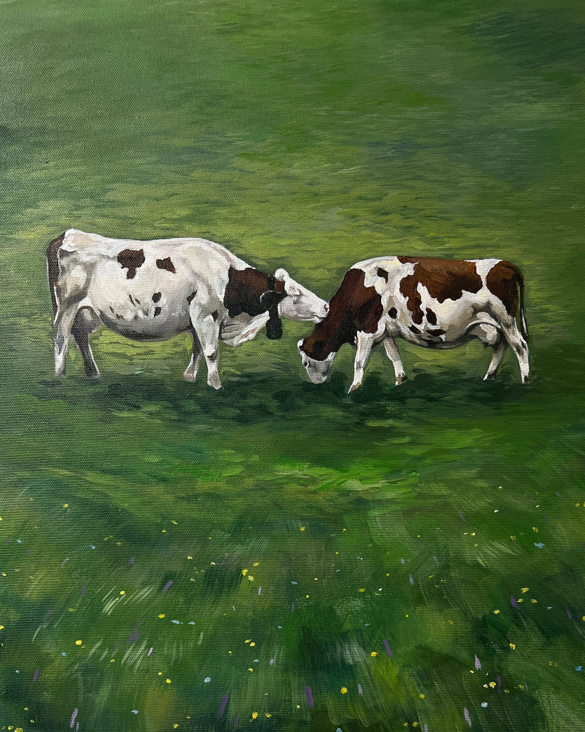 Painting of two cows grazing on green grass with a palette of artist's colors in the foreground.